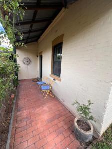 a patio with two chairs and a window on a house at The Tamarisks at Rosevale in Bathurst