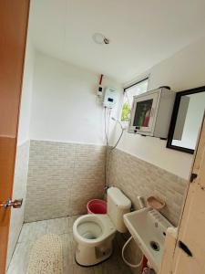 a small bathroom with a toilet and a sink at Cabin de Paulin 1 in Tagaytay