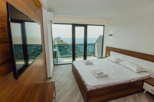 a bedroom with a bed with a view of the ocean at Apartments Beach Tower in Batumi