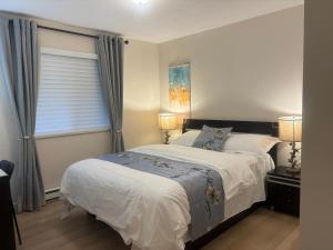 Un dormitorio con una cama grande y una ventana en Coquitlam center, 2 bedroom suite, walking to skytrain en Port Coquitlam