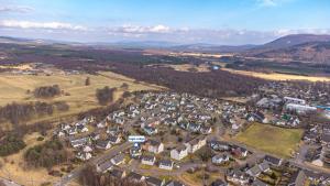 an aerial view of a small village in the hills at Eagle Lodge - Aviemore Lodges in Aviemore