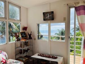 a living room with windows and a table and a view of the ocean at Cabin de Paulin 1 in Tagaytay