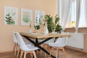 a dining room table with white chairs around it at CityLife: Gemütlich • Groß • Zentral • Parkplatz in Braunschweig