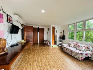 a living room with a couch and a tv at Cabin de Paulin 1 in Tagaytay