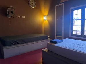 a bedroom with two beds and a clock on the wall at Buena Onda Backpackers in San Juan del Sur