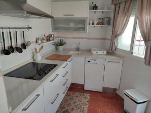 a kitchen with white cabinets and a sink at Mina42 by 7Escalones in Rota
