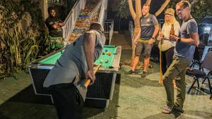 a group of people standing around a pool table at The New Njiro Legacy in Arusha