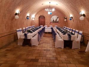 ブジェツラフにあるPenzion Miluškaの白いテーブルと青い椅子が備わる宴会場