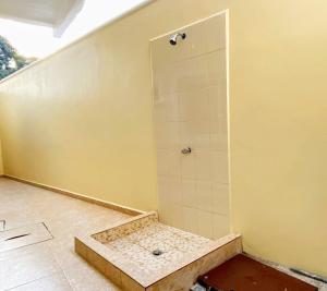 a bathroom with a shower with a tile floor at Maho's Apartamentos in Tela