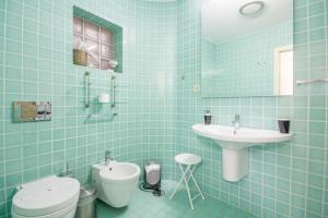 ポルトにあるOHH - Ganesha studio- Oporto Centerの青いタイル張りのバスルーム(トイレ、シンク付)