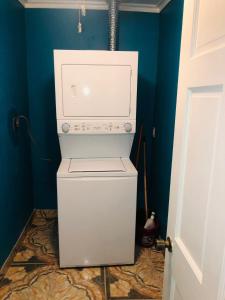 a washer and dryer in a room with a blue wall at JB's Cottage in Bottle Creek Settlements