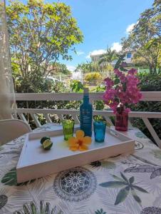 レ・トロワ・イレにあるTikoule t2 avec piscine Trois Iletsのワイン1本と花のトレイ