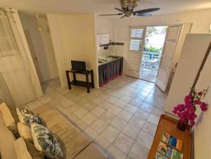 レ・トロワ・イレにあるTikoule t2 avec piscine Trois Iletsのソファと天井ファンのあるリビングルーム