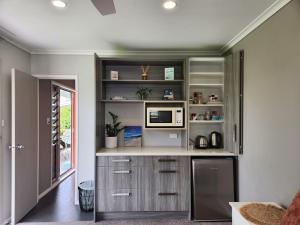 a kitchen with gray cabinets and a counter at Hahei Getaway Tahi in Hahei