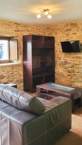 uma sala de estar com um sofá de couro e uma mesa em AG Casa Do Castro en rural Galicia a 14km de playa em Esto