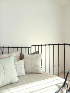 a bed with pillows on it in a bedroom at Ericeira Vibes in Ericeira