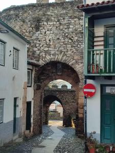 um arco num antigo edifício de pedra com uma rua em Casa da Porta de Santo António em Brangança