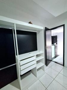a white entertainment center with a large television in a room at Flat Central do Martins in São Luís
