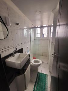 a white bathroom with a sink and a toilet at Flat Central do Martins in São Luís