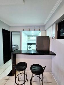 a kitchen with two chairs and a counter in a room at Flat Central do Martins in São Luís