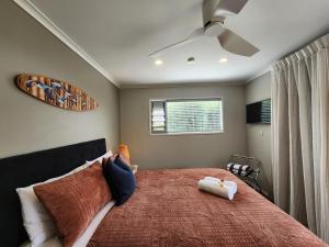 a bedroom with a large bed with a ceiling fan at Hahei Getaway Tahi in Hahei