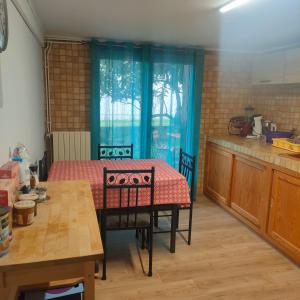 eine Küche mit einem Tisch, einem Tisch und Stühlen in der Unterkunft Casa Tranquila Cerca el Estuario in Pauillac