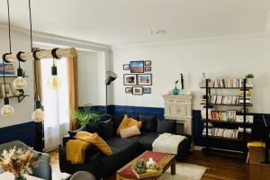 a living room with a couch and a book shelf at Comfortable 76m apartment in Paris