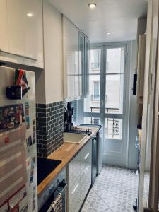cocina con fregadero y encimera con ventana en Comfortable 76m apartment en París