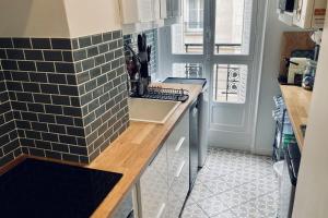 eine Küche mit einer Spüle und einer Arbeitsplatte in der Unterkunft Comfortable 76m apartment in Paris