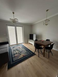 a living room with a table and chairs and a television at Apartament Różana in Lublin