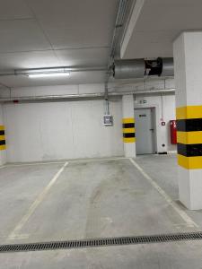 an empty parking garage with yellow and black stripes at Apartament Różana in Lublin