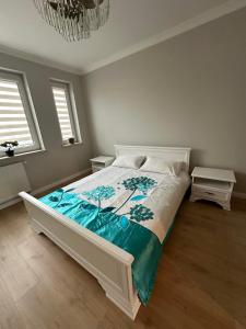 a bedroom with a white bed with a blue blanket at Apartament Różana in Lublin +5 photos