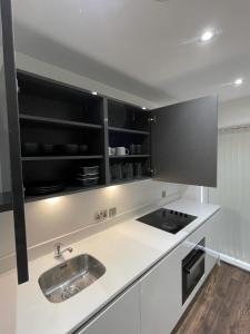 a kitchen with a sink and a stove at Room in Modern Luxury 3 bed Apartment in City Center in Birmingham