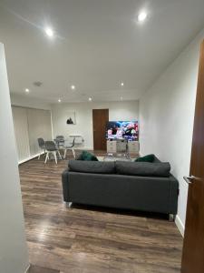 a living room with a couch and a flat screen tv at Room in Modern Luxury 3 bed Apartment in City Center in Birmingham