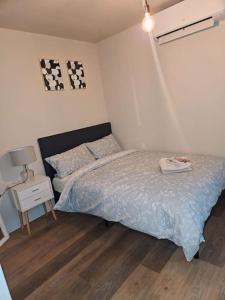 a bedroom with a bed and a table with a lamp at 1-bed flat near Romford station in Romford