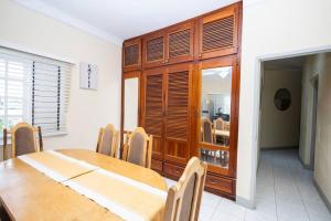 a dining room with a table and a wooden cabinet at Sun Haven Villa in Discovery Bay, St. Ann in Discovery Bay