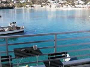 a boat in a body of water with a table at Isalos Stay Andros in Batsi