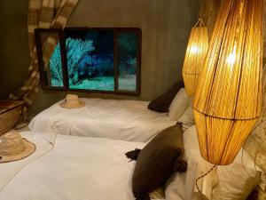 a bedroom with two beds and a window at Villa Mama comfort et hospitalité in Essaouira