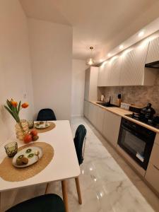 uma cozinha com uma mesa branca e uma bancada branca em Dragon apartament em Lublin