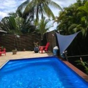 uma piscina azul num quintal com palmeiras em KAZ A PIRATES em Petit-Bourg