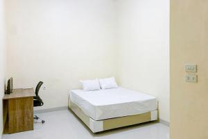 a white room with a bed and a desk at RedDoorz @ Jalan Ryacudu Korpri Lampung in Kedaton