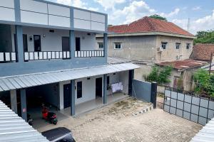 une vue de tête d'un bâtiment avec une moto garée devant dans l'établissement RedDoorz @ Jalan Ryacudu Korpri Lampung, à Kedaton