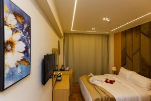 um quarto de hotel com uma cama e um quadro na parede em Rizk Pyramids View Hotel no Cairo