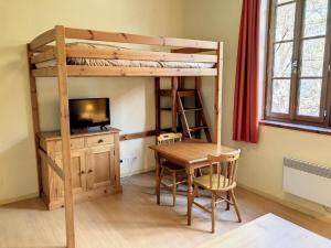 Cette chambre dispose de lits superposés, d'une table et d'un bureau. dans l'établissement Appartement Grand Hôtel Aulus-les-Bains, à Aulus-les-Bains