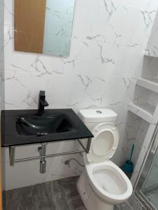 La salle de bains est pourvue de toilettes et d'un lavabo. dans l'établissement madison place, à Praia