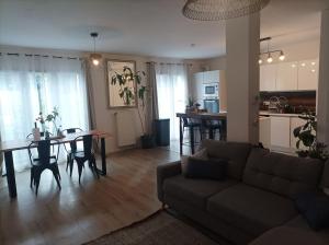 a living room and kitchen with a couch and a table at Disney - Résidence Juan Valera in Vaujours