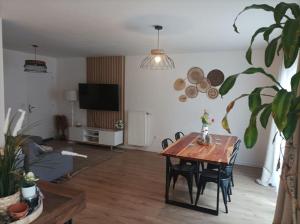 a living room with a table and chairs and a tv at Disney - Résidence Juan Valera in Vaujours