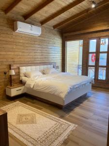 1 dormitorio con 1 cama grande en una pared de madera en اكواخ همسي كوي, en Tabuk