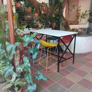 a table and two chairs in a patio with plants at Chambres en Ville in David