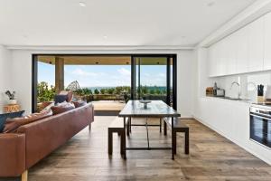 a living room with a couch and a table at Ocean Views, Deck and Parking at Beach Apartment in Collaroy